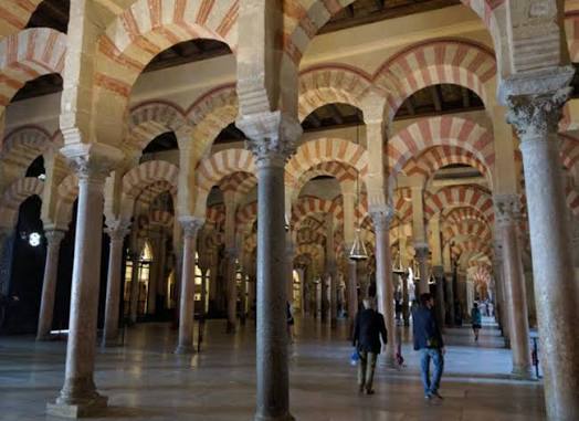 The interior of the Mezquita of Córdoba — the Great Mosque whose forest of red-and-white striped horseshoe arches and columns became the defining architectural image of Al-Andalus, and whose influence is still traceable in every great Moroccan mosque and madrasa